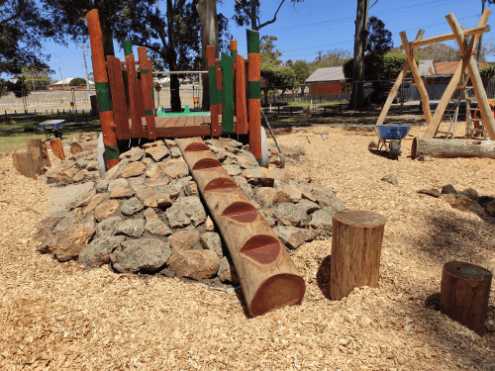 Timber ladder up rock wall connecting to timber play fort