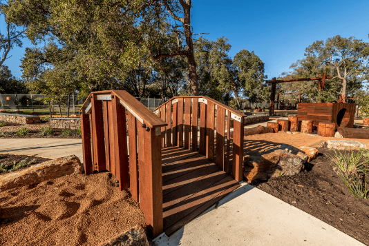 Timber bridge connecting two paths in large timber playground