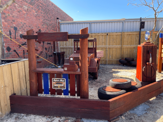 Timber mechanics play equipment with timber fuel pump, timber truck, timber reception and money till and timber tyre stack
