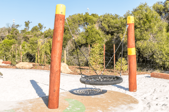 Circle swing between two timber pillars with yellow tops
